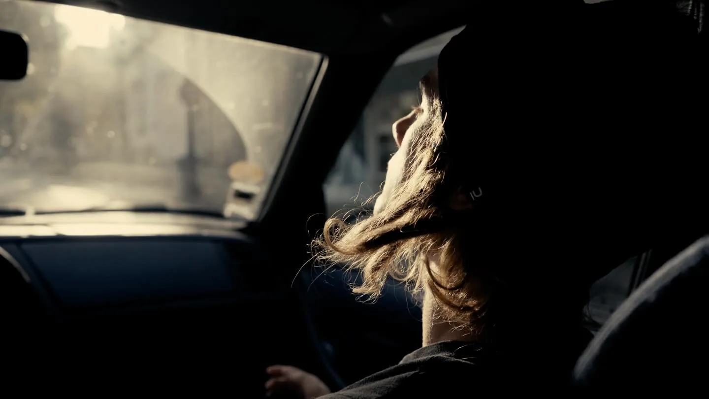 Book photo : portrait de profil d'une femme dans une voiture, cheveux au vent, lumière naturelle